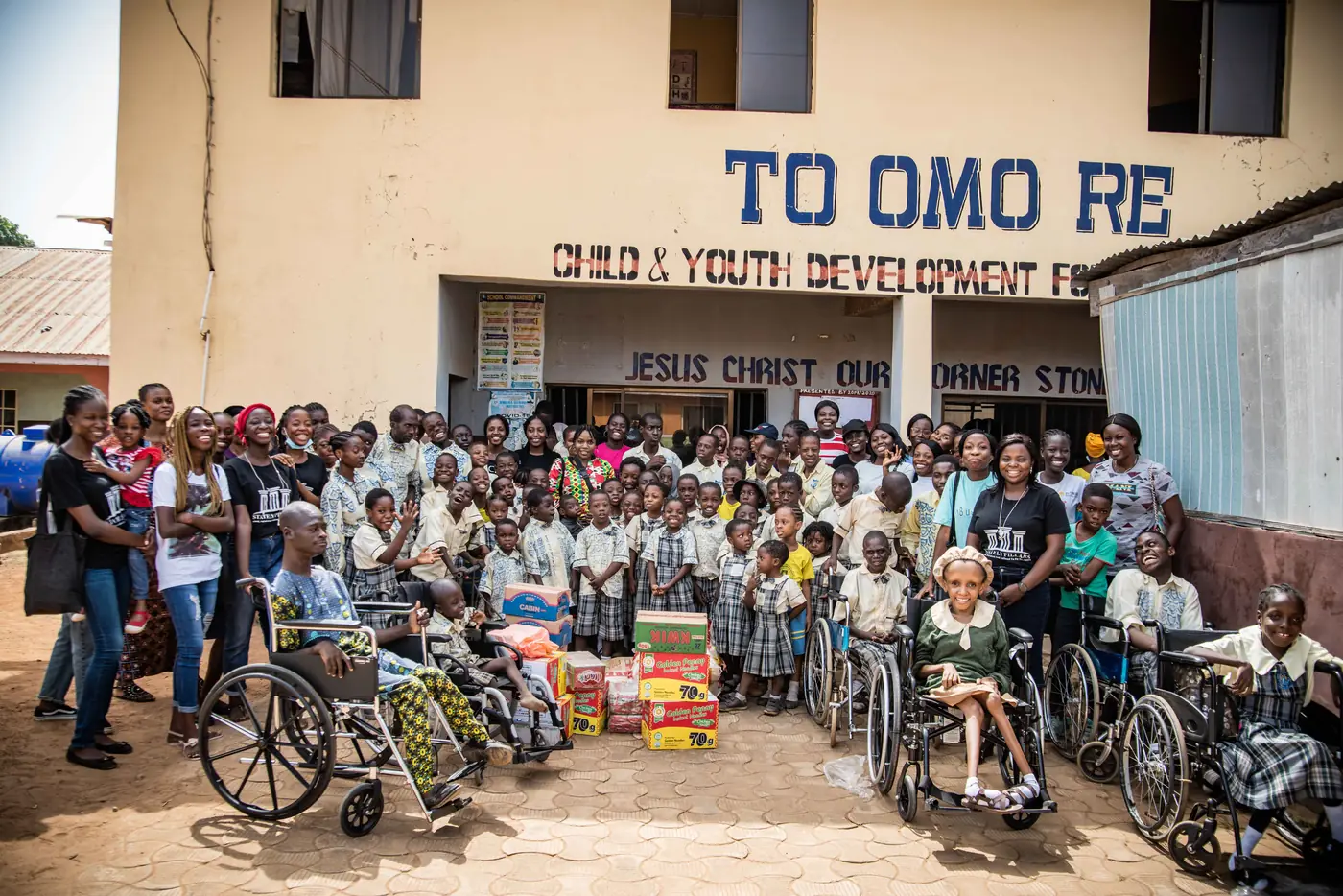 The team and students outside the school