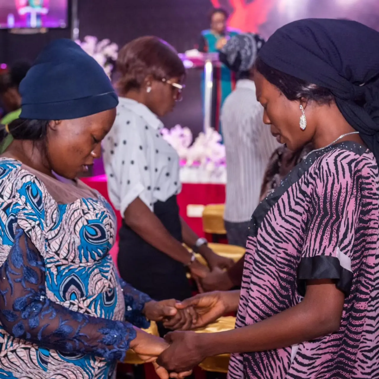 Women holding hands in prayer