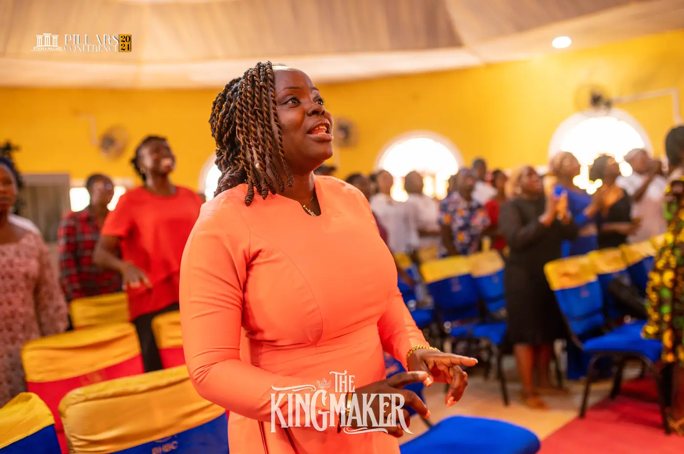 A woman in orange worshipping
